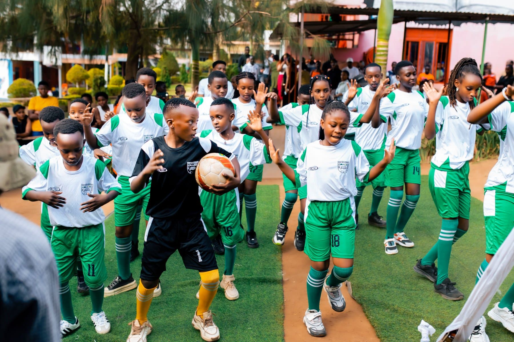 Pupils in green football kit on the pitch