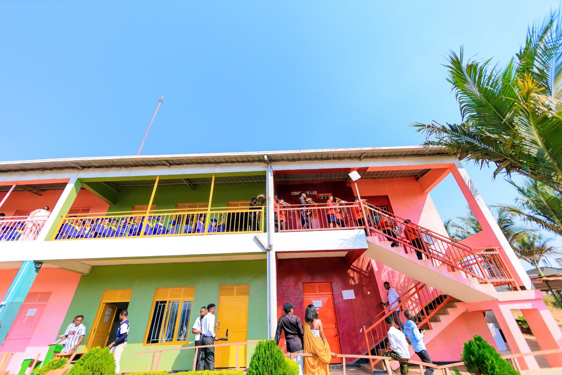 The school building, painted pink and green, with an open walkway